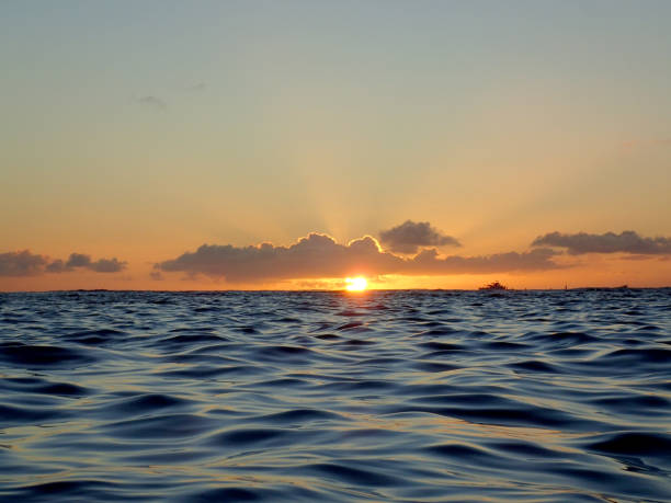 Shot of a sunset by the sea, sky, and mountains, deep colors. Taken in Kauai, Hawaii, during the day.