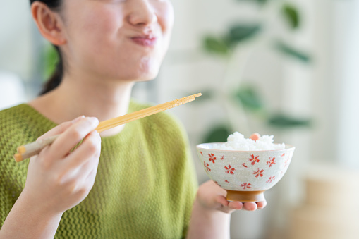 Young Japanese woman eating white rice for breakfast