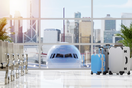 Travel and vacation concept with suitcases in empty airport hall with airplane and city background 3d render