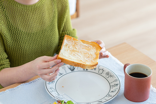 Young Japanese woman eating breakfast at home