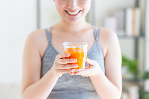 Young Japanese woman drinking vegetable juice