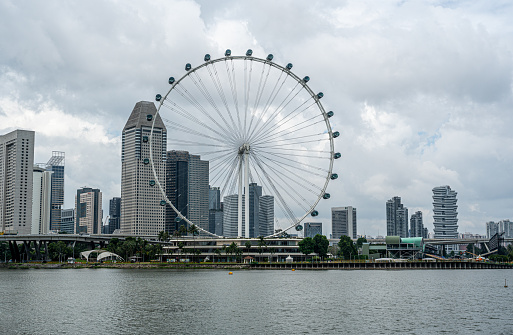 Singapore, June 14, 2019. Aerial view of the skyline of Singapore during a beautiful sunny day with the financial district in the distance. In front people are visiting the famous Merlion fountain at Marina Bay. Singapore is located in Southeast Asia.