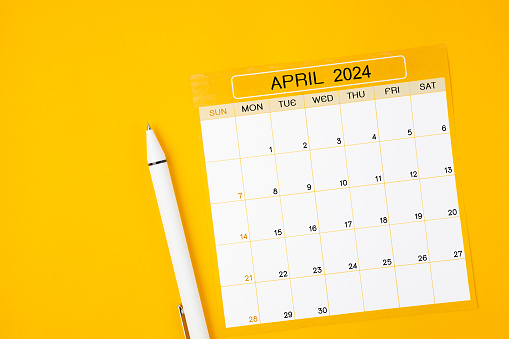 April 2024 Monthly calendar for 2024 year with pen on yellow background.