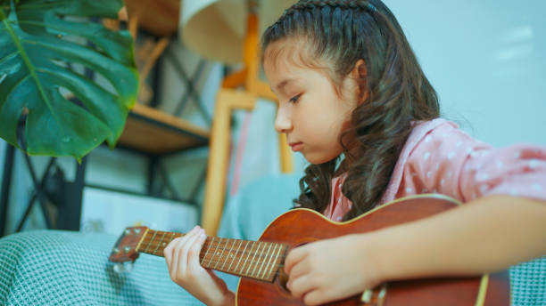 istock Little Chinese Girl Singing and Playing Ukulele. 1978989517
