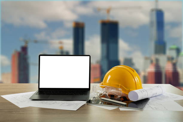 istock Yellow hardhat and laptop at a construction site, emphasizing safety and technology in the building industry 1979088028