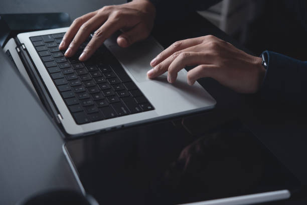 istock Man working on laptop computer and digital tablet on office table at workplace. Business man using portable computer device, online working, surfing the internet 1979093141