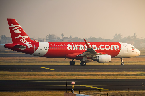 AirAsia Indonesia Airbus A320 taxiing to Runway 25R at Soekarno Hatta International Airport in the morning