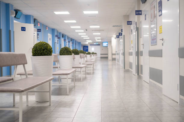 istock Empty modern hospital corridor, clinic hallway interior background with white chairs for patients waiting for doctor visit. Contemporary waiting room in medical office. Healthcare services concept. 1979109780