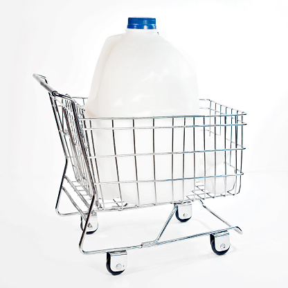 Big jug of milk in a miniature shopping cart