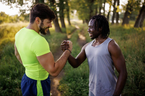 istock Two young male joggers greeting each other in nature 1979239406