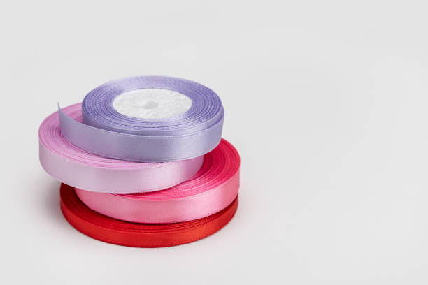 Blue ribbon spool on white table against blue background
