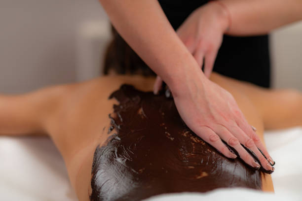 istock Beauty treatment featuring a rich cocoa paste, as skilled hands deliver a luxurious chocolate body massage experience 1979313432