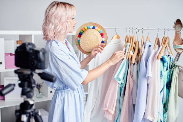istock Woman selecting outfits on camera 1979344101