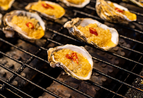 The brightly colored Chinese oysters illuminated by warm lights, bursting with delectable flavors