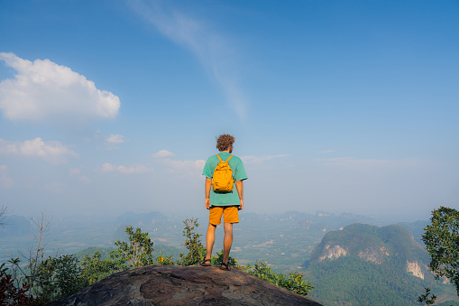 Man enjoying nature on viewpoint on top of the mountain overlooking Krabi