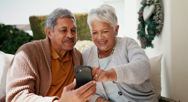 Phone, networking and senior couple relaxing in a garden and bonding together on social media. Happy, smile and elderly man and woman scroll on mobile app or the internet with cellphone in nature.