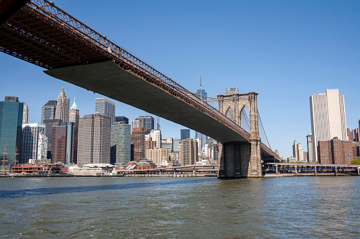 View of the Manhattan Bridge, the coastline and the East River during a sunny springtime day at Brooklyn, New York, USA.