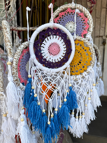 Stock photo showing close-up view of colourful dream catchers decorated with beads on Indian market stall.