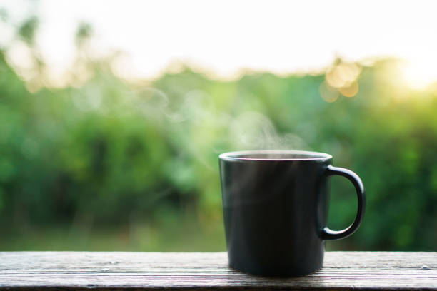Beautiful sunrise lighting in the morning with a hot coffee and Moka Pot close up with copyspace. Beautiful natural sun lighting bokeh and coffee cup in the morning.