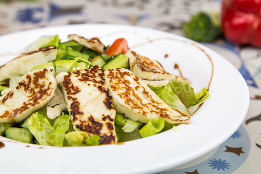 Halloumi Salad with cucumber and tomato served in dish isolated on table top view of arabic food