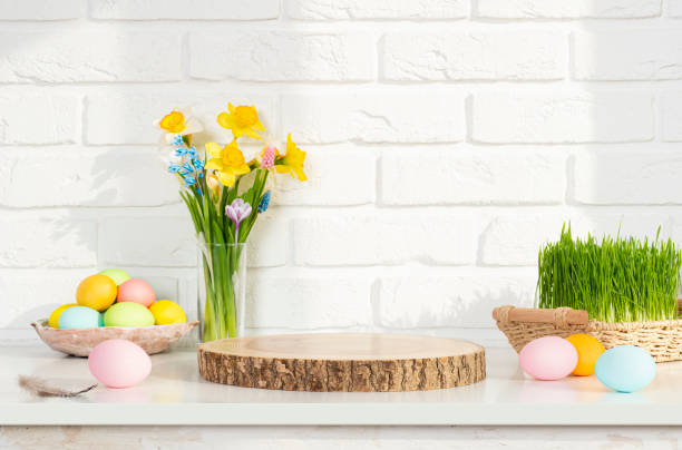 istock Empty round wooden podium for product presentation with spring flowers  and easter eggs on light background 1979448131