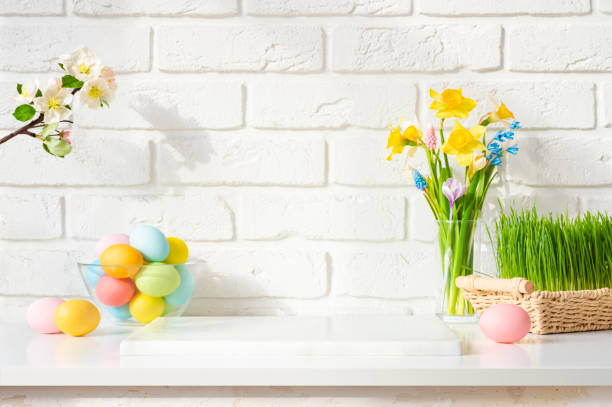 istock Stone podium on table decorated with easter eggs and spring flowers on white brick wall background 1979448637