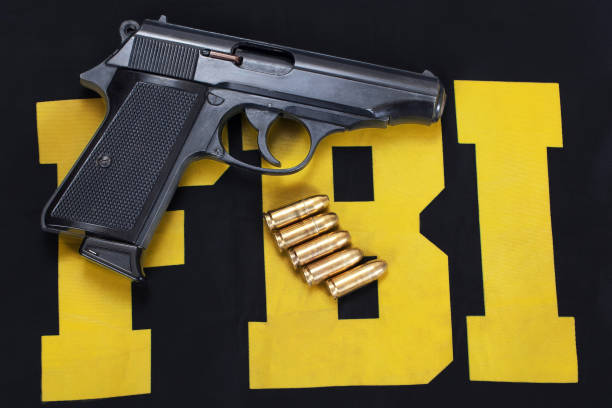 istock FBI concept with handgun and ammunition on black uniform 1979454491