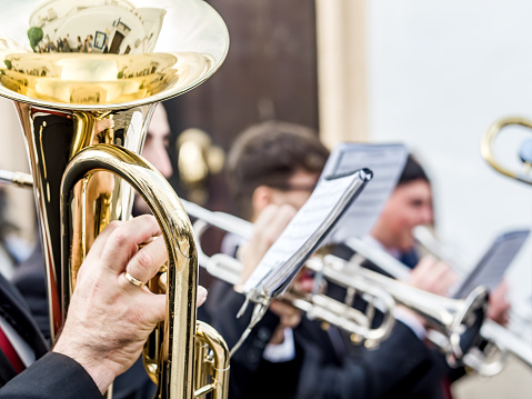 Close-up of musicians playing trumpets, focused on hands and instruments.