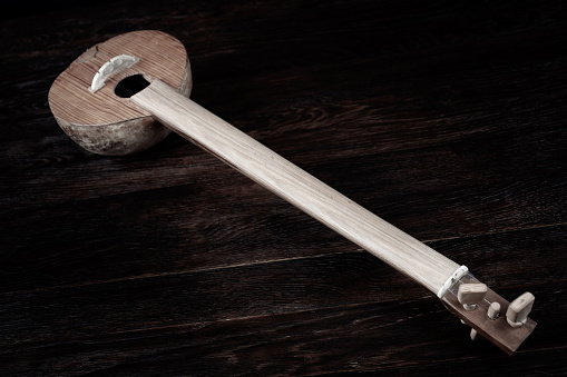 Turkish tambour. Long-necked folk string instrument of the lute family on wooden table.