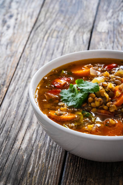istock Fresh vegetable soup with lentil on wooden table 1979468740