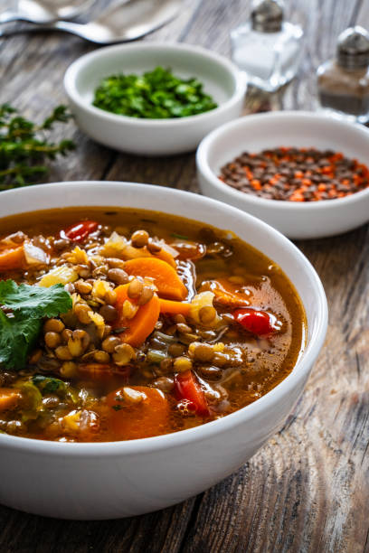 istock Fresh vegetable soup with lentil on wooden table 1979469254