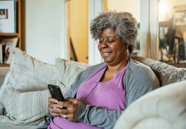 istock Senior African woman at home using technologies - Woman using smart phone 1979478696