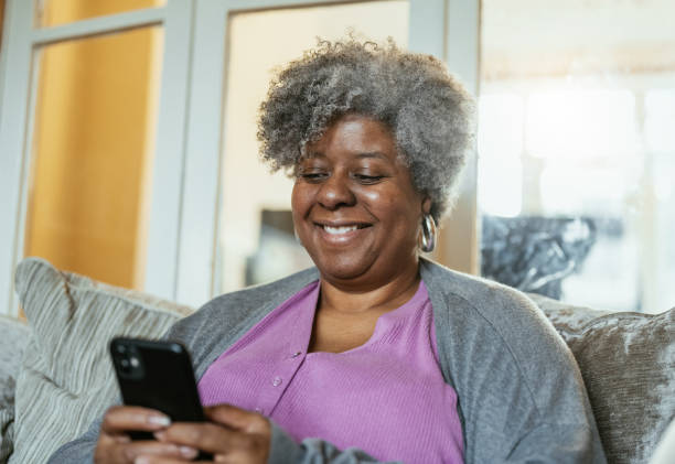 istock Senior African woman at home using technologies - Woman using smart phone 1979479722