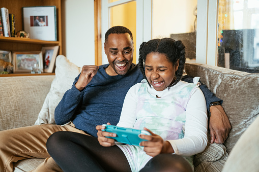 African family at home in the UK. Mature parents spending time with teenage daughter