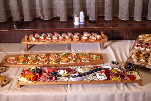 Eating at event. An appealing catering display of carved pineapple, cantaloupe, grapes, and mixed berries on reflective glass platter.