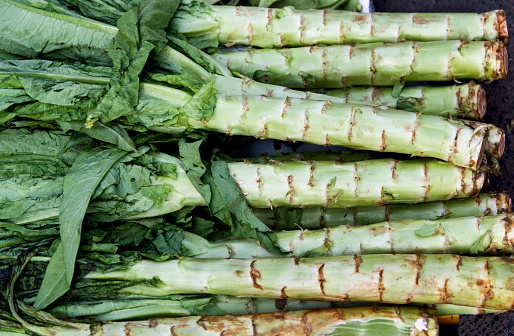 Pile of asparagus lettuce stems in market