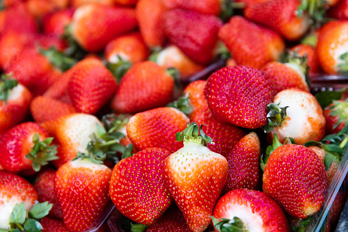 Punnet of strawberries in plastic containers for sale at a local market