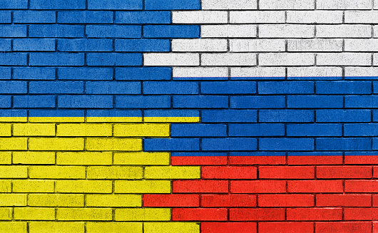 Flags of Russia and Ukraine is painted on brick wall