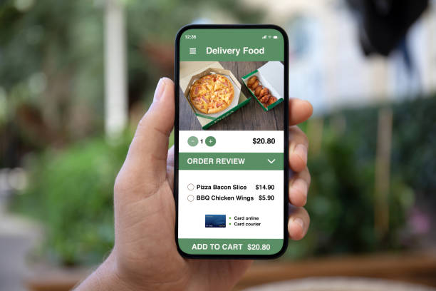 istock Man hand holding phone with food delivery app on screen 1979503998