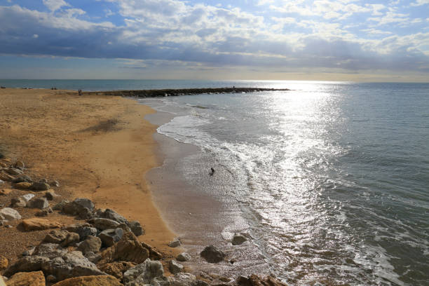Chipiona beach and breakwater on a cloudy day of winter