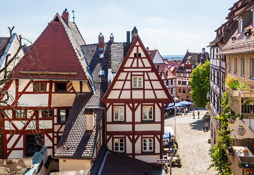 Nuremberg, Germany - August 23, 2023: Medieval half-timbered houses in the old town near the Tiergärtnertor square, seen from the Am Ölberg alley with Albrecht Dürer's House-museum in the background.