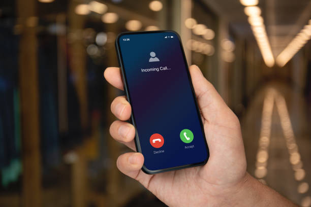istock Man hand hold phone with incoming call screen street lights 1979535780