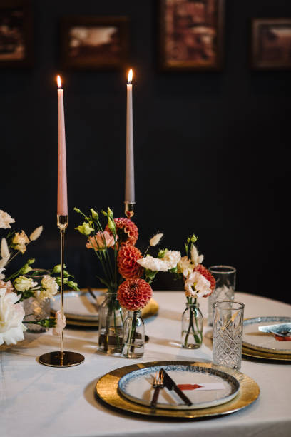 istock Wedding set up, reception closeup. Festive dinner table decorated with flower and greenery, candles. Birthday celebration in restaurant. Serving, setting table. Plate, silverware cutlery, glasses. 1979576848