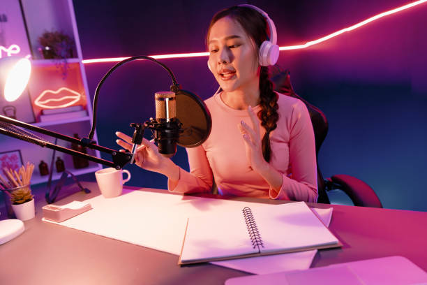istock Smiling creative young beautiful Asian influencer talking in channel. Stratagem. 1979587933