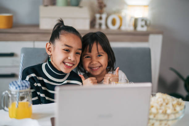 istock Two little sisters have fun using a laptop together 1979591976