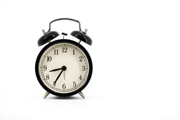 istock A black alarm clock with two bells on top, chrome handle, and legs, set against a white background. Timeless design meets functionality in this sleek, monochromatic timepiece. 1979613629