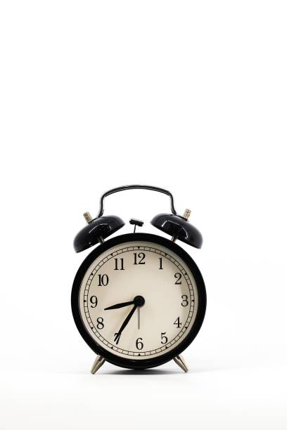 istock A black alarm clock with two bells on top, chrome handle, and legs, set against a white background. Timeless design meets functionality in this sleek, monochromatic timepiece. 1979613638