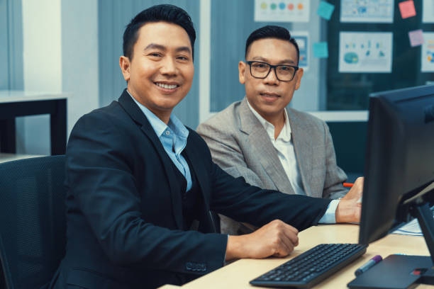 istock Smart businessman looking at camera while sitting with colleges.Intellectual. 1979631435