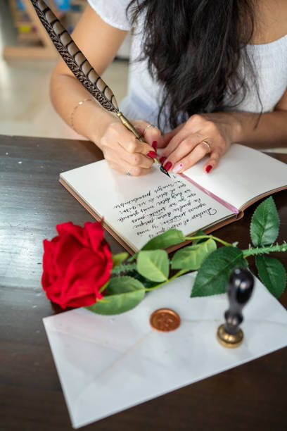 Close-up of a Caucasian female hand holding a fountain pen and writing a purchase contract in Czech language. Concept for old law, legal issues and old handwritten documents.