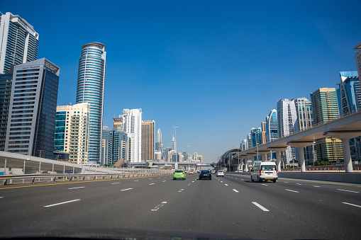 Dubai, UAE - December 1, 2023: View of the roadside from car windshield to Dubai city, United Arab Emirates. High quality photo